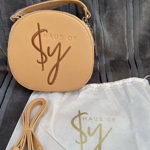 Haus of $y's tan signature logo bag.